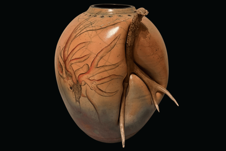 Pot that is made of clay with a mule deer antler attached, and was Raku-fired